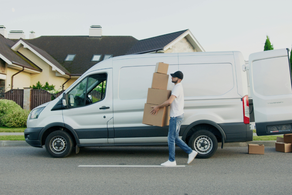 A delivery van and driver in a neighborhood.