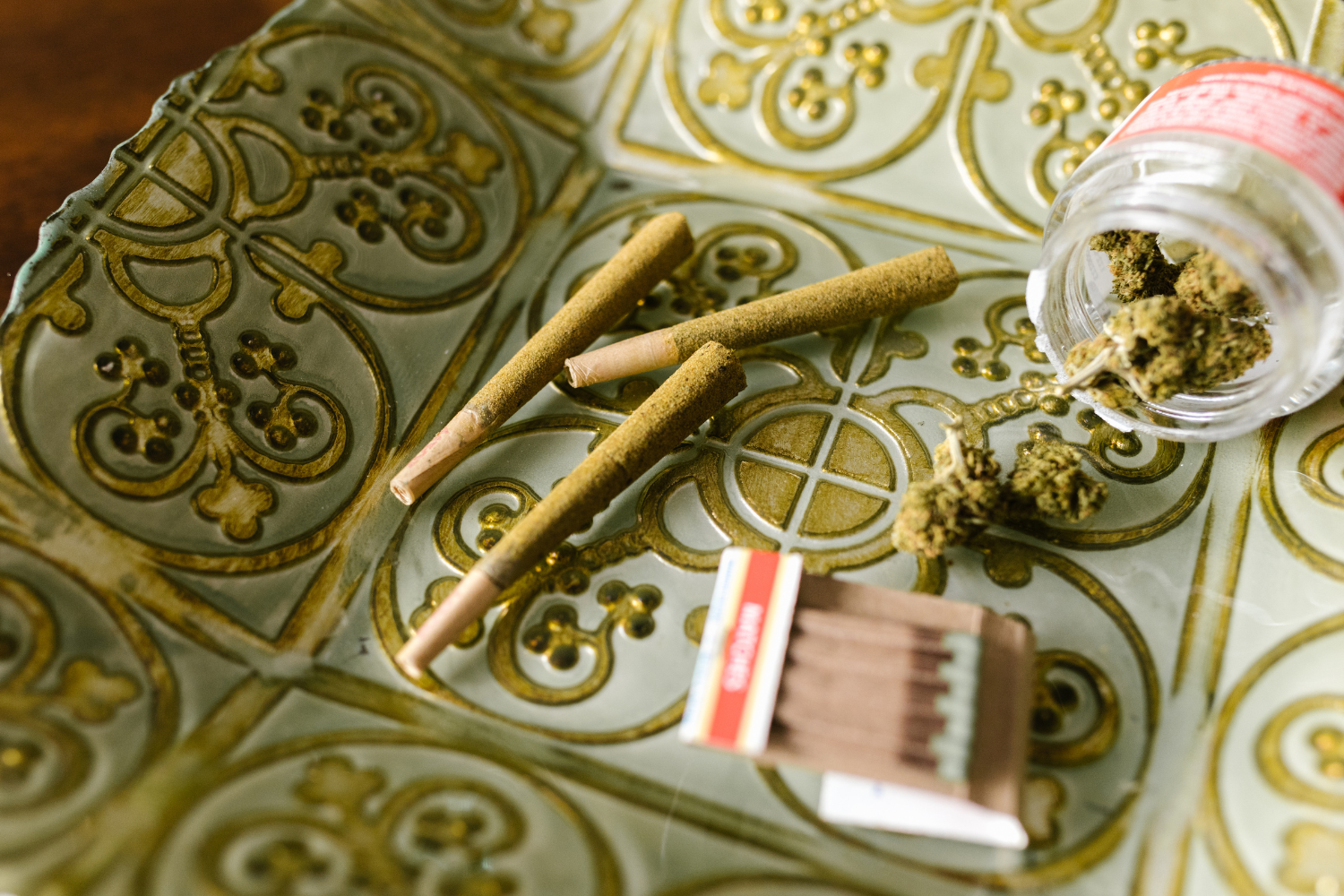 Rolled cannabis joint on tray with a match